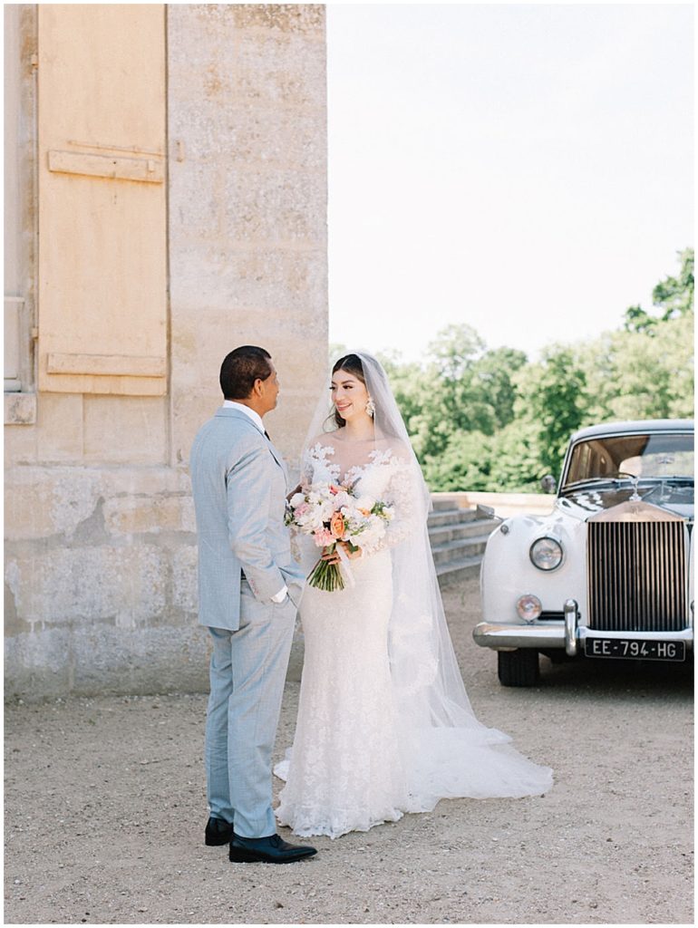 bride and groom and vintage rolls royce at Chateau de Villette in Paris, France