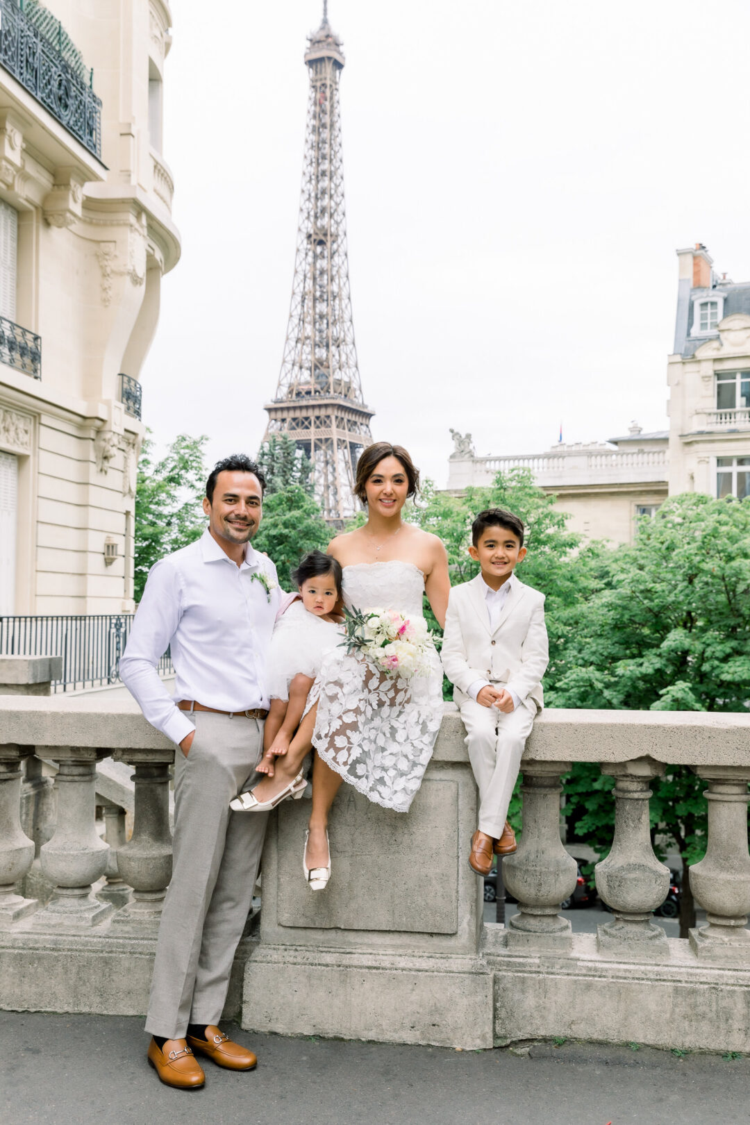 Bride and groom renewing their vows in Paris with their two kids near the Eiffel Tower at sunrise.